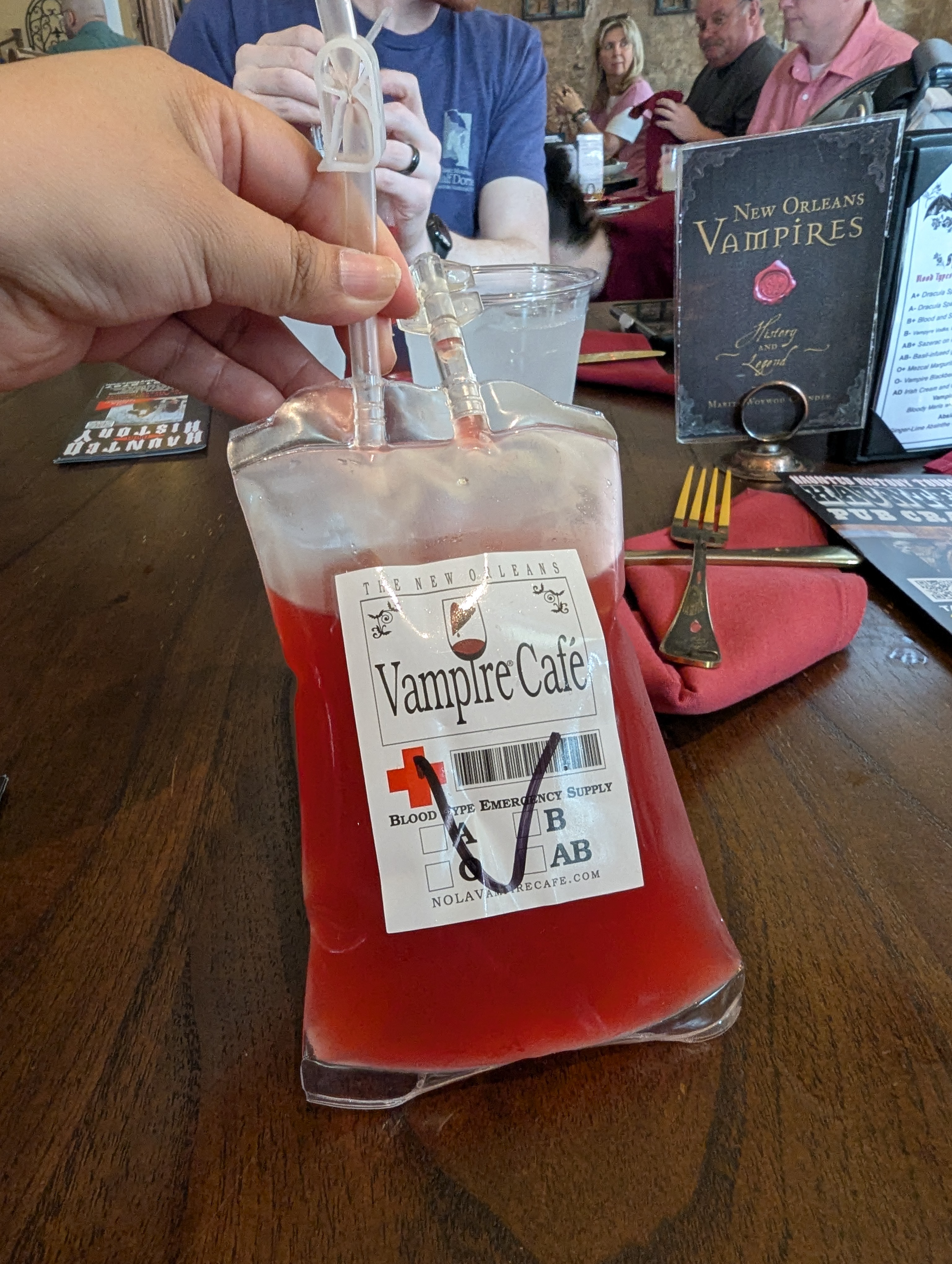 Plastic pouch styled like a medical blood bag, filled with dark red liquid and labeled with vampire-themed branding, served as a novelty drink at the Vampire Cafe in New Orleans